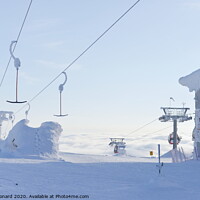 Buy canvas prints of At the top of ski lifts rising above the clouds in Finland. by Rhys Leonard