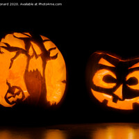 Buy canvas prints of Two intricately carved halloween pumpkins lit by candle tea lights by Rhys Leonard