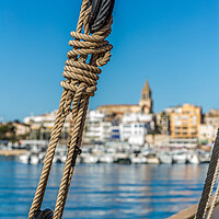 Buy canvas prints of Small Spanish town in Costa Brava, Palamos.Foreground a sail boat rigging. by Arpad Radoczy