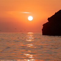 Buy canvas prints of Warm orange sunset reflecting off the sea at South by Richard Fearon