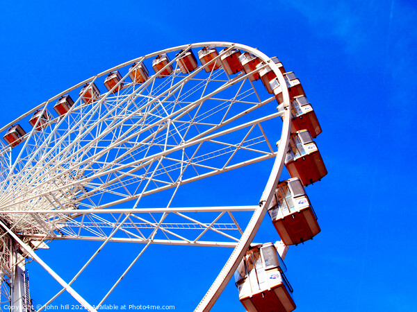 Ferris wheel against a blue sky. Picture Board by john hill