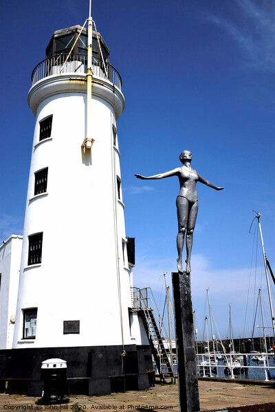 Harbour lighthouse and bathing belle statue at Scarborough. Picture Board by john hill