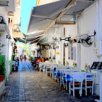 Buy canvas prints of Food and drink in a back alley of Skiathos town in Greece.   e by john hill