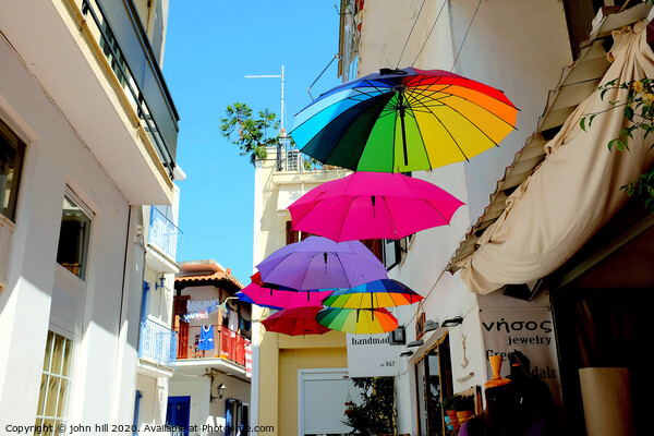 Colorful Parasols hanging in street at Skiathos Town in Greece.  Picture Board by john hill