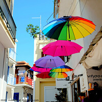 Buy canvas prints of Colorful Parasols hanging in street at Skiathos Town in Greece.  by john hill