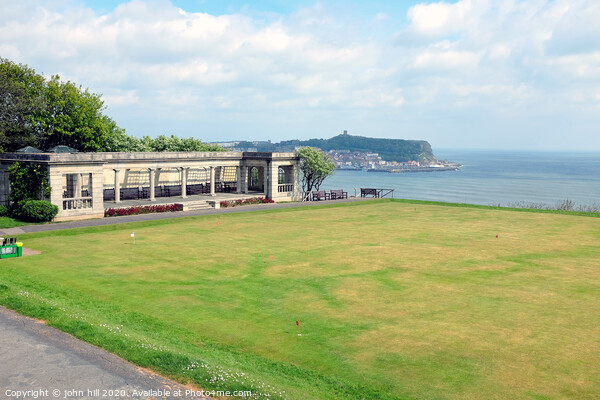 Shelter and putting green with the town in the background at Scarborough in Yorkshire Picture Board by john hill