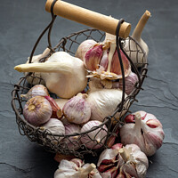Buy canvas prints of Still life, Garlic in a basket on a slate plate by Thomas Klee