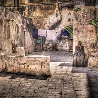 Buy canvas prints of A backyard in Jerusalem old city with a resident sitting in deep contemplation.  by Peter Bolton