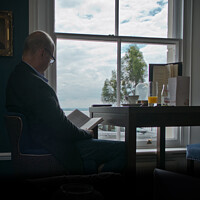 Buy canvas prints of 'Quiet time'. Man reading a book in front of a window. by Peter Bolton