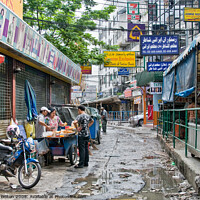 Buy canvas prints of A side street in central Bangkok, Thailand, after heavy rain. by Peter Bolton