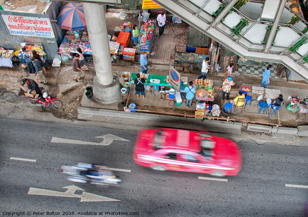 Overhead view of a street with food vendors and traffic speeding past. Bangkok, Thailand. Picture Board by Peter Bolton