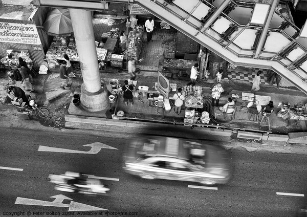 Black and white view from overhead of a street with food vendors and traffic. Bangkok, Thailand. Picture Board by Peter Bolton