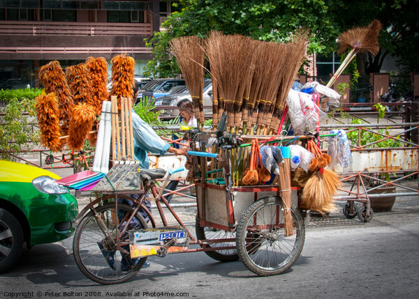 Mobile street vendor selling brushes from a pedal tricycle in central Bangkok. Picture Board by Peter Bolton