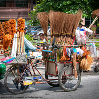 Buy canvas prints of Mobile street vendor selling brushes from a pedal tricycle in central Bangkok. by Peter Bolton