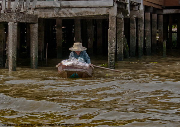 A local resident in her day to day mode of transport on a canal in Bangkok, Thailand. Picture Board by Peter Bolton