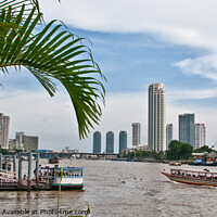 Buy canvas prints of A view of ferries and landing stages on the Chao Phraya River, Bangkok, Thailand. by Peter Bolton