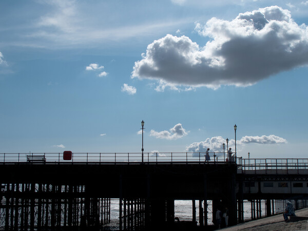 Part of the walkway in silhouette at Southend Pier, Essex, UK, with isolated clouds overhead. Picture Board by Peter Bolton