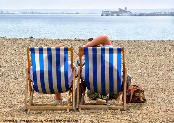 A couple on the beach in deckchairs silhouetted through the canvas at Southend on Sea, Essex, UK. Picture Board by Peter Bolton