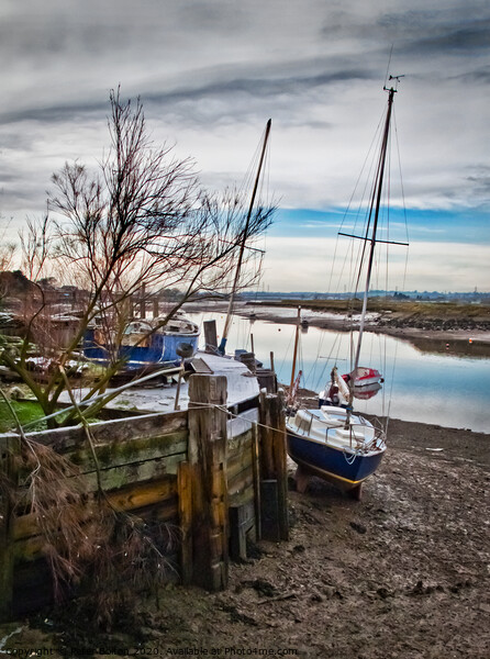 A mooring dock on the River Crouch with boats waiting for the tide. Hullbridge, Essex, UK. Picture Board by Peter Bolton