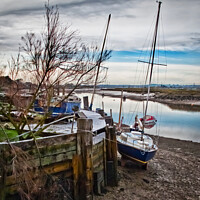Buy canvas prints of A mooring dock on the River Crouch with boats waiting for the tide. Hullbridge, Essex, UK. by Peter Bolton