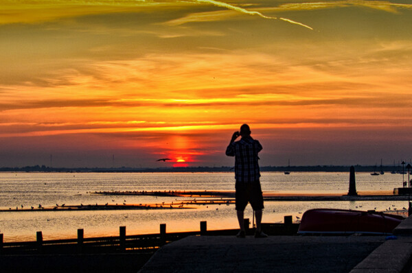 Watching the sunset at Chalkwell, Southend on Sea, Essex, UK. Picture Board by Peter Bolton