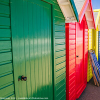 Buy canvas prints of Colourful Beach Huts and a deck chair in Whitby by Michael Shannon