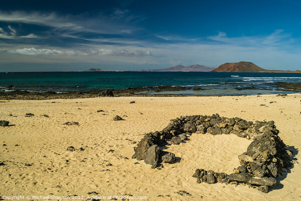 Rock beach shelter on Fuerteventura. In the distan Picture Board by Michael Shannon
