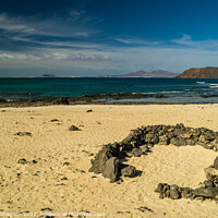 Buy canvas prints of Rock beach shelter on Fuerteventura. In the distan by Michael Shannon