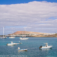 Buy canvas prints of Small boats and Playa Blanca resort, Lanzarote by Michael Shannon