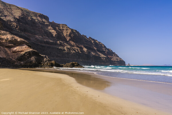 The beach at Orzola near the cliffs of the Punta F Picture Board by Michael Shannon