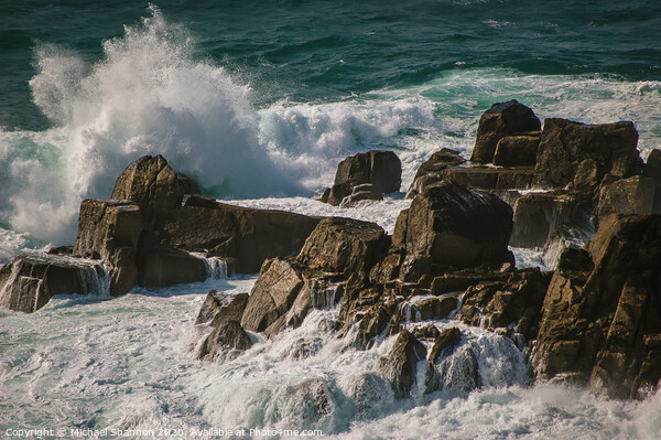 Waves crash against the rocks at Lands End, Cornwa Picture Board by Michael Shannon