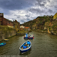 Buy canvas prints of Seagulls Soar Over Stormy Staithes by Janet Carmichael