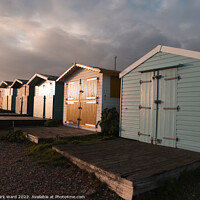 Buy canvas prints of Glowing Autumn Beach huts by Mark Ward