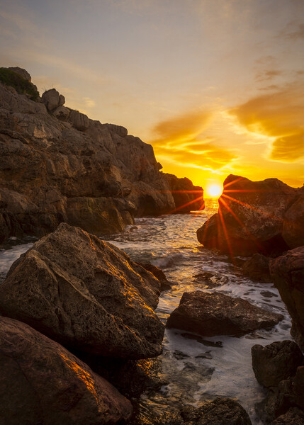 Sunrise between the rocks in a cove of La Renega, Oropesa Picture Board by Vicen Photo
