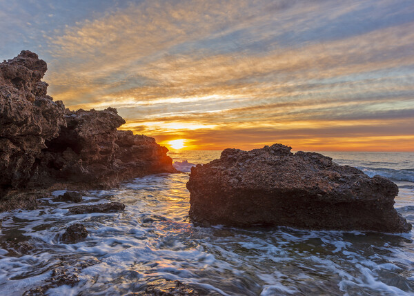 Photography with a sunrise between the rocks in a seascape Picture Board by Vicen Photo