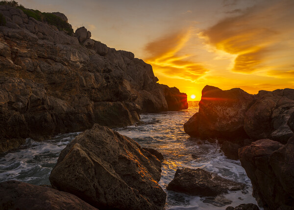 A sunrise between the rocks in a cove in La Renega, Oropesa Picture Board by Vicen Photo