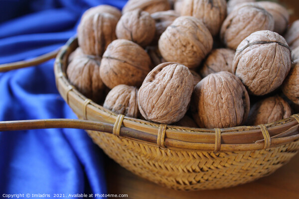 Walnuts in a basket with blue tablecloth Picture Board by Imladris 