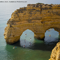 Buy canvas prints of Kayaks and sup boards peddling under the Arco Natural on the Algarve coast in Portugal. by Kristof Bellens