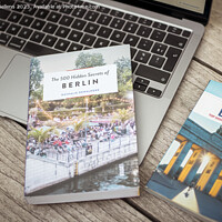 Buy canvas prints of Planning a trip to Berlin with laptop on wooden table and travel guides by Kristof Bellens