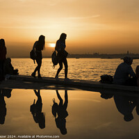 Buy canvas prints of Silhouettes of some young people with beautiful reflections on the water at sunset by Engin Sezer