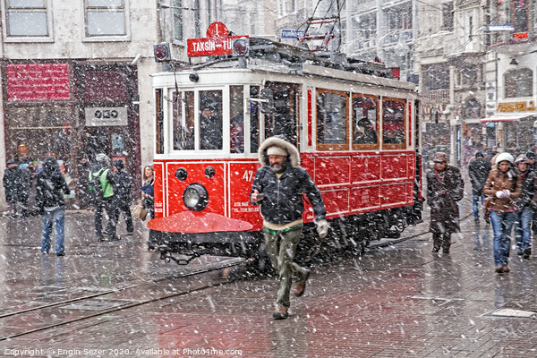 A nostalgic tram was passing by The Istiklal Street when snowfalls at Istanbul Picture Board by Engin Sezer