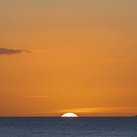 Buy canvas prints of The sun setting over the horizon with an orangey in the sky by Rory Hailes