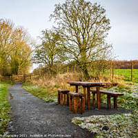 Buy canvas prints of Wooden table and chairs at a seating area on a countryside trail in winter by SnapT Photography