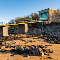 Buy canvas prints of A coastal boat house and boat launch ramp slipway on a rocky beach in winter by SnapT Photography