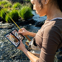Buy canvas prints of A close up of an asian female selecting fly fishing flies from a box by SnapT Photography