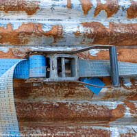 Buy canvas prints of A blue rachet strap wrapped around a rusty corrugated iron metal sheet by SnapT Photography
