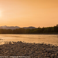 Buy canvas prints of A fisherman walking along a gravel bar beside the Skeena River at sunset by SnapT Photography