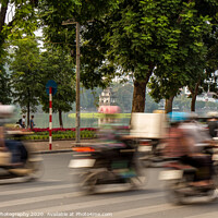 Buy canvas prints of Motorbike motion at Hoan Kiem lake and turtle tower in the background by SnapT Photography
