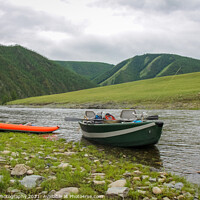 Buy canvas prints of A fishing raft and kayak anchored on grass bank beside the river by SnapT Photography