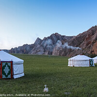 Buy canvas prints of A row of Mongolian gers at a camp at sunset on a summers night, with chimney smoke by SnapT Photography